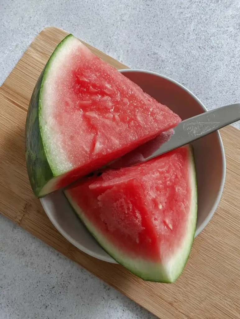 Ninja Creami Watermelon Sorbet 28 Fresh watermelon cut into slices on a wooden board
