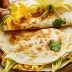 Close-up of squash blossom quesadillas with cilantro garnish.