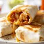 A close-up of several golden brown Bean and Cheese Burritos on a white plate, one sliced open revealing melted cheese and beans, with salsa and avocado blurred in the background.