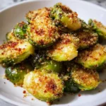 A white bowl filled with crispy Air Fryer Parmesan Brussels Sprouts, topped with golden-brown breadcrumbs and cheese.