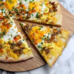 A delicious breakfast pizza with sunny-side-up and scrambled eggs, sausage, diced vegetables, and fresh herbs on a wooden board.