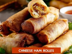 A close-up of a plate piled high with crispy, golden-brown Chinese Egg Rolls, one cut open to reveal a savory filling.