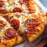 Close-up of a hand pulling a slice of delicious pepperoni pizza with melted cheese, showcasing a golden brown Homemade Pizza Dough.