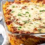 Close-up of a bubbling Lasagna Casserole in a glass baking dish, topped with melted mozzarella and fresh parsley.
