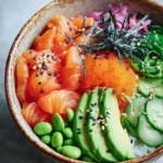 A vibrant Salmon Sushi Bowl overflowing with fresh salmon, avocado, roe, edamame, and cucumber slices, topped with seaweed.