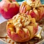 Two delicious Bloomin Baked Apples, fanned out and topped with vanilla ice cream, caramel, and a spice sprinkle.