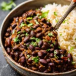 A rustic bowl filled with delicious Cuban beans and rice, garnished with fresh cilantro, ready to be enjoyed.