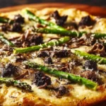 A gourmet Morel and Asparagus Pizza, richly topped with green asparagus spears and dark morel mushrooms on a wooden surface.