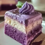 A delectable slice of Ube Tres Leches Cake with vibrant purple sponge, white creamy filling, purple glaze, and a mint garnish.