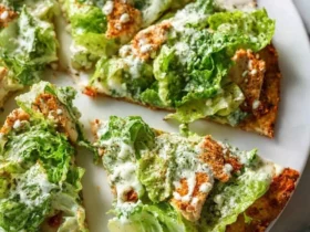 Chicken Caesar Salad Pizza 47 Sliced Chicken Caesar Salad Pizza topped with fresh romaine lettuce, creamy dressing, and croutons on a crispy crust.