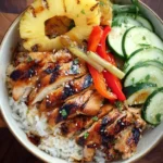 Grilled Hawaiian Chicken Teriyaki Bowls with rice, pineapple, cucumber, and peppers in a ceramic bowl.