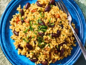 Mediterranean rice and beans 52 Mediterranean rice and beans served on a vibrant blue plate with fresh herbs sprinkled on top.