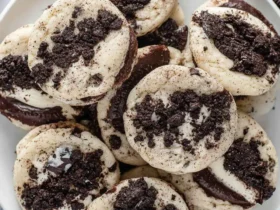 Oreo cheesecake cookies 46 A white plate piled high with Oreo cheesecake cookies topped with chocolate cookie crumbles.