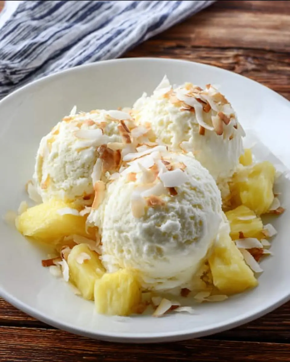 Creamy pina colada ice cream being scooped from a Ninja Creami pint container
