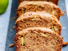 Apple Cinnamon Zucchini Bread 53 Sliced Apple Cinnamon Zucchini Bread with glaze on a dark slate serving board with fresh apples.