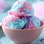 Two scoops of colorful Cotton Candy Ice Cream swirled with pink and blue hues served in a pink bowl.