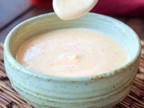 Japanese Steakhouse White Sauce 51 Creamy Japanese Steakhouse White Sauce in a green ceramic bowl with a white spoon lifting some sauce.