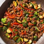 Mediterranean Ground Beef and Vegetables stir-fry with zucchini, broccoli, and red peppers in a skillet.