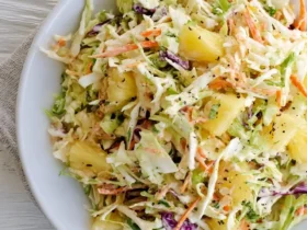 Fresh Pineapple Coleslaw with shredded cabbage, carrots, and pineapple chunks in a creamy dressing served in a white bowl.