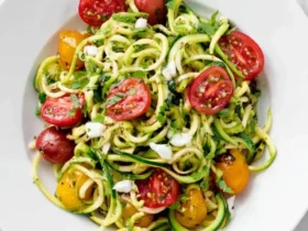 Zoodles with Summer Vegetables 46 Fresh Zoodles with Summer Vegetables served in a white bowl, featuring spiralized zucchini, cherry tomatoes, and crumbled cheese.