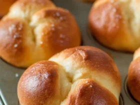 Golden brown Cloverleaf Dinner Rolls baked in a muffin tin, showing their classic three-section pull-apart shape.
