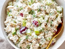cottage cheese chicken salad 47 Creamy cottage cheese chicken salad with grapes, celery, and fresh dill served in a white speckled bowl with a gold spoon.