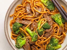 Low-Carb Beef & Broccoli Noodles served in a ceramic bowl with chopsticks, featuring tender beef strips and fresh broccoli.