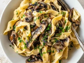 Pasta with Portobello Mushroom 53 Creamy Pasta with Portobello Mushroom served in a white bowl with fresh herbs sprinkled on top.