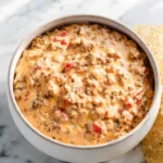 Creamy Rotel Dip Recipe served in a white bowl with tortilla chips on a marble surface.