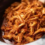 Shredded BBQ chicken crockpot filled with tender, saucy pulled chicken ready to serve.