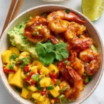 Shrimp Avocado Bowls with Mango Salsa served in a ceramic bowl with lime and chopsticks.