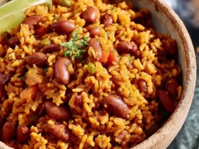 Spanish rice and beans 53 Spanish rice and beans served in a rustic bowl with a lime wedge and fresh cilantro garnish.