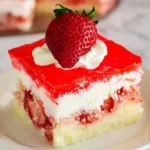 A slice of Strawberry Jello Poke Cake topped with fresh strawberry and whipped cream on a white plate.