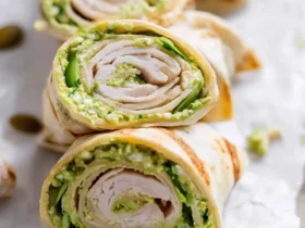 Turkey Pesto Tortilla Roll Ups 47 Close-up of Turkey Pesto Tortilla Roll Ups sliced into spirals, revealing layers of turkey, green pesto, and fresh vegetables.