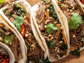 Vietnamese Instant Pot Beef Brisket Tacos with shredded meat, cilantro, peanuts, and chili on flour tortillas.