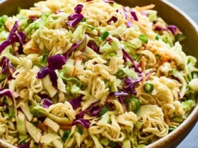 Ramen Noodle Salad with Cabbage 50 A rustic bowl filled with Ramen Noodle Salad with Cabbage, featuring green and purple cabbage, green onions, and crunchy ramen noodles.