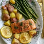 Salmon Potatoes and Asparagus Sheet Pan Dinner served on a floral plate with lemon slices and fresh dill garnish.