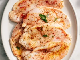 Turkey Steaks 53 Seasoned turkey steaks arranged on a white plate, garnished with fresh herbs and spices.
